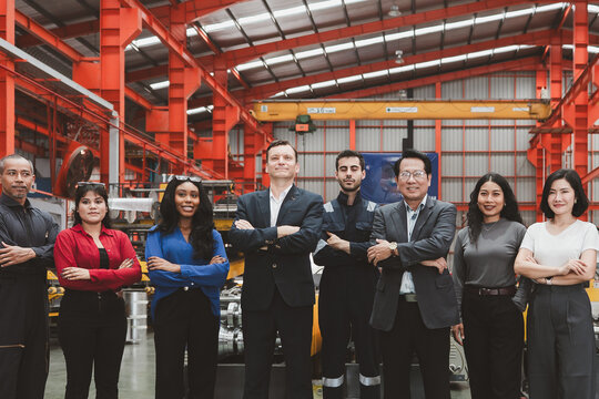 Industrial teamwork and leadership. Diverse business professionals and factory staff stand together inside a manufacturing plant. Industry, teamwork, leadership, workforce, factory