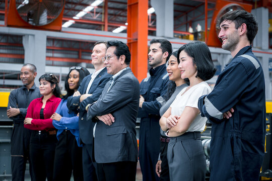 Industrial teamwork and leadership. Diverse business professionals and factory staff stand together inside a manufacturing plant. Industry, teamwork, leadership, workforce, factory