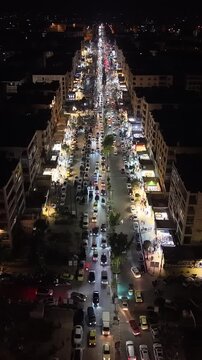 Aerial night view of an urban landscape in Syria featuring glowing city lights and illuminated streets.  Post-war Syrian cityscape and daily life at night.