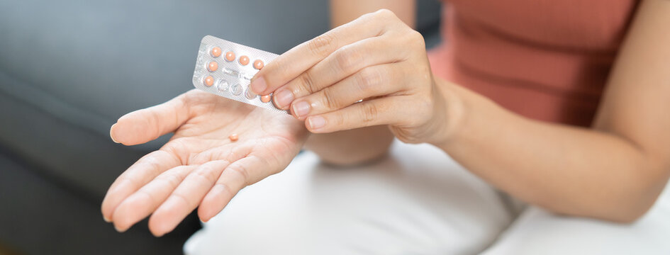 Contraception and pregnancy concept asian young woman, girl hand opening birth control pills, holding hormonal oral contraceptive medicine, take pharmaceutical to prevention, safe virus sex disease.
