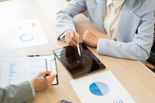 Business meeting, asian group brainstorm analysis on graph data of cost plan. financial consult planning investor asses and present to client, client and advisor review investment strategy in office.