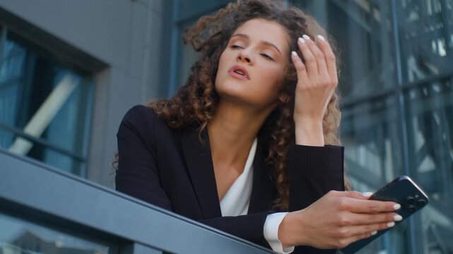 Boring tired Caucasian business woman feeling stress with mobile phone technology troubled unhealthy businesswoman female girl manager with smartphone feel headache worried with bad news email in city