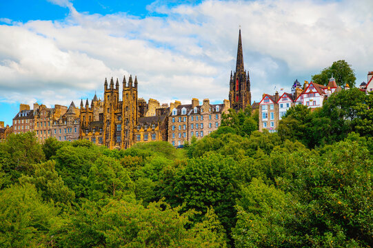 Edinburgh Old Town skyline by The Mound and Castlehill, with New College, The Hub spire, Ramsay Garden, and lush Princes Street Gardens below in Scotland.