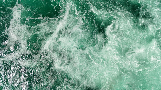 Aerial view of the turbulent, foamy waters of the Rhine Falls with swirling currents and white water rapids in Schaffhausen, Schaffhausen, Switzerland.