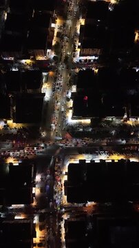 Aerial night view of an urban landscape in Syria featuring glowing city lights and illuminated streets.  Post-war Syrian cityscape and daily life at night.
