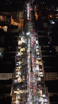 Aerial night view of an urban landscape in Syria featuring glowing city lights and illuminated streets.  Post-war Syrian cityscape and daily life at night.