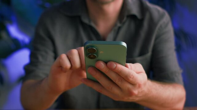 Modern office worker or freelancer using a smartphone in a stylish loft studio. Mobile communication, remote work, digital technology, creative business, productivity and modern workspace.