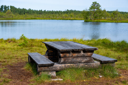 Wooden table and bench near calm lake in Sweden