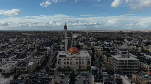 Aerial drone view of an Islamic mosque featuring a prominent dome and tall minarets. Concept of world religions, faith, and Islamic culture in post-war Syria.