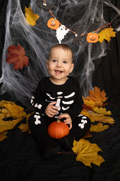 Baby in Skeleton Costume with Pumpkin and Leaves Halloween