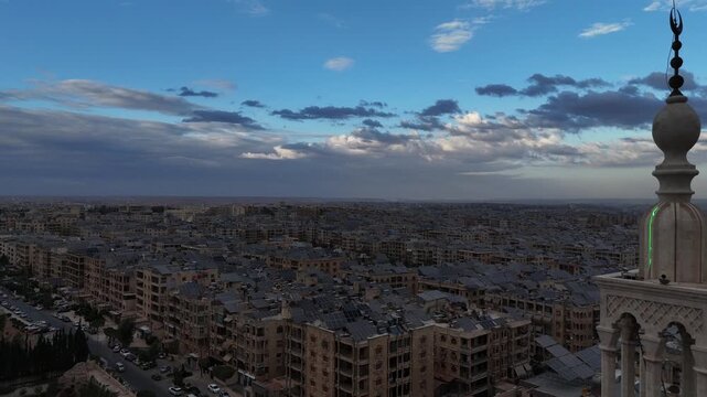 Aerial drone view of an Islamic mosque featuring a prominent dome and tall minarets. Concept of world religions, faith, and Islamic culture in post-war Syria.