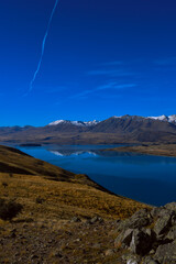 Fototapeta premium Lake Tekapo and snow-capped Southern Alps reflected in calm blue water, New Zealand