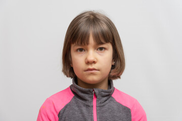 Serious young girl looking directly at camera in studio portrait © Anton