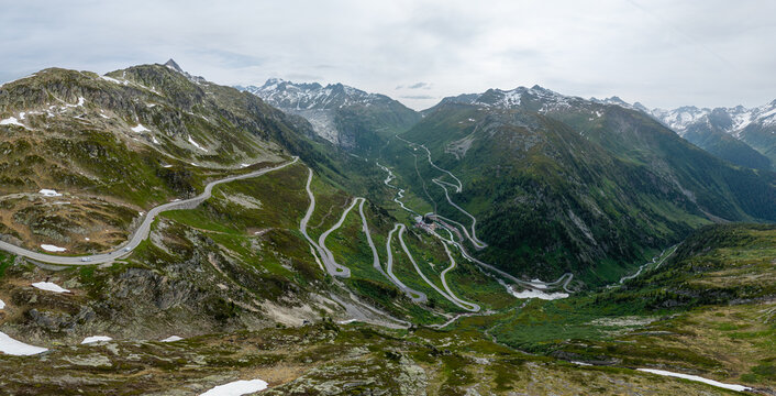 High angle panoramic view of the winding serpentine mountain road and dramatic alpine landscape of Grimsel Pass in the Swiss Alps, Switzerland.