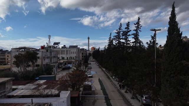 Aerial drone view of an Islamic mosque featuring a prominent dome and tall minarets. Concept of world religions, faith, and Islamic culture in post-war Syria.