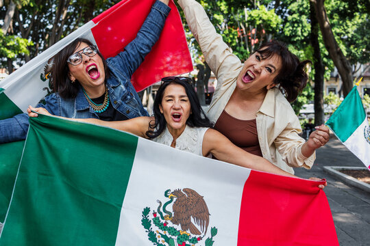 Mexican senior women with flags to celebrate mexican independence day and cheering Viva Mexico, mature people having fun