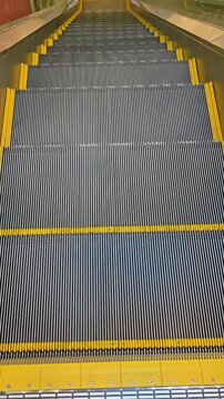 Moving steps of an empty escalator staircase inside an office shopping mall building, Elevation Automatic Transport, Travel Infrastructure, Modern Stairway Machine
