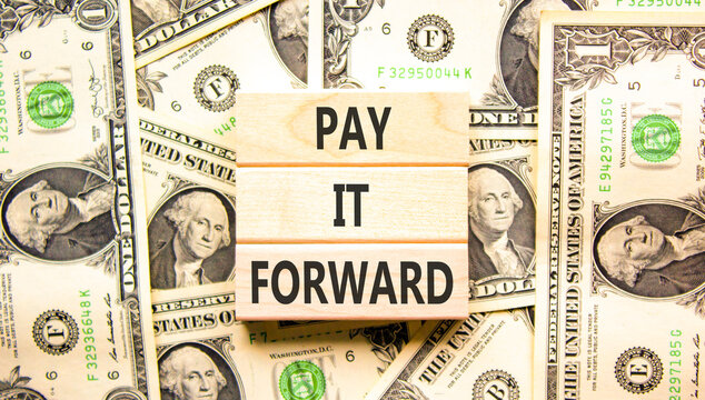 Pay it forward words symbol. Concept words Pay it forward on beautiful wooden blocks. Beautiful dollar bills background. Dollar bills. Business and pay it forward concept. Copy space.