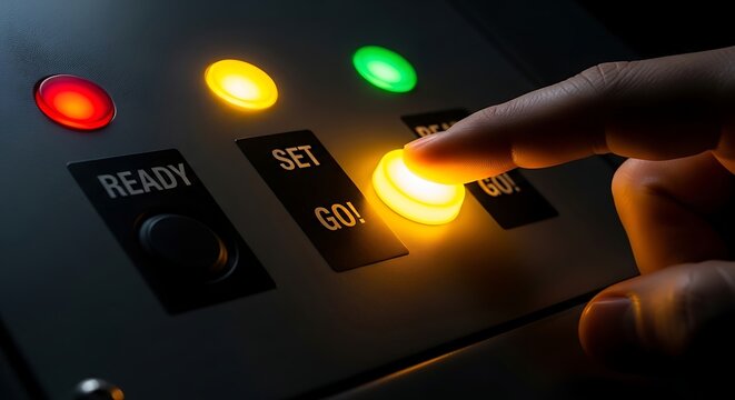 Close up of a hand pressing a yellow button with red yellow and green lights illuminated