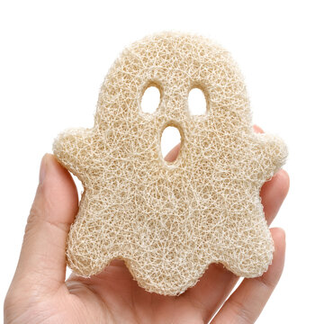 Ghost shaped natural loofah sponge held by hand. Halloween holiday.