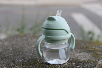 Fototapeta premium lost OXO Tot Transitions Straw Cup with Handles on an old concrete wall in Toronto's Rosedale