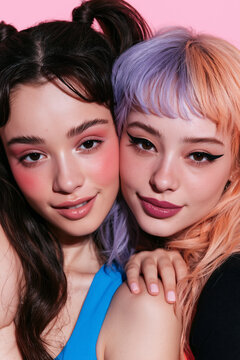 two women of different backgrounds flirting in stylish alternative fashion, two diverse women sharing a playful romantic moment, multicultural women with colorful hair and glossy makeup