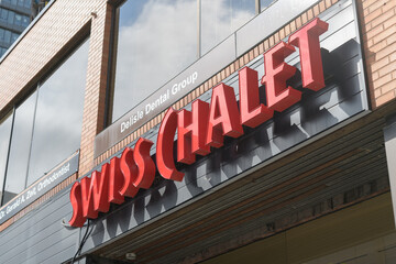 Fototapeta premium exterior building facade and sign of Swiss Chalet, restaurant chain, located here at 1560 Yonge St, inside Delisle Court, Toronto