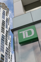 Fototapeta premium TD corporate logo sign outside branch at 2 St Clair Av E with view of One Delisle condo tower, Toronto