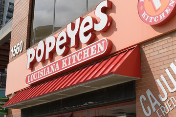 Fototapeta premium exterior building facade and sign of Popeyes Louisiana Kitchen, a chicken restaurant chain, located here at 1560 Yonge St, Delisle Court, Toronto