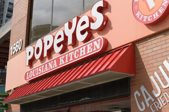 exterior building facade and sign of Popeyes Louisiana Kitchen, a chicken restaurant chain, located here at 1560 Yonge St, Delisle Court, Toronto