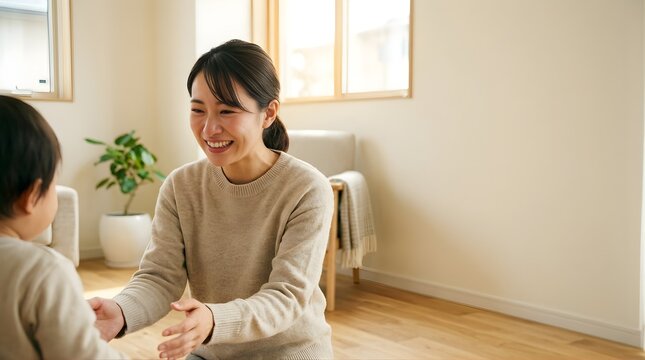 Japanese mother smiling and playing with her toddler son at home