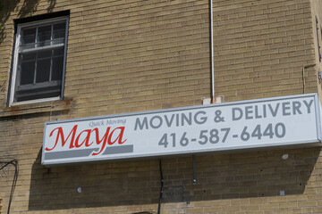 Fototapeta premium exterior building wall and sign of Maya Moving and Delivery, a moving and storage service, located here at 1630 Bloor St W, Toronto