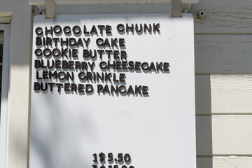 Fototapeta premium cookie menu (chocolate chunk, birthday cake, cookie butter, blueberry cheesecake, lemon crinkle, buttered pancake) outside Andrea's Cookies, a cookie shop, located here at 1632 Bloor St W, Toronto