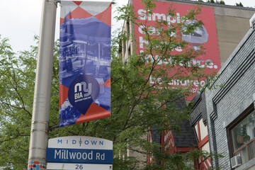 Fototapeta premium Midtown Toronto street sign at Millwood Rd, including BIA banner