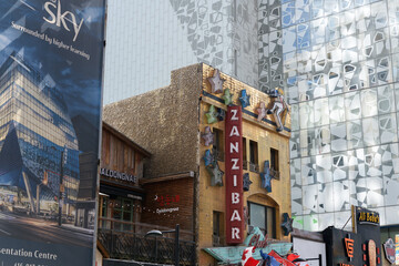 Fototapeta premium exterior building facade and signage of Club Zanzibar, an adult entertainment club (tucked between a restaurant and a TMU building) located at 359 Yonge St, Toronto (morning of August 15, 2026)