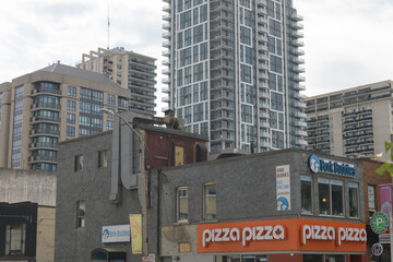 Fototapeta premium exterior corner view of building with sign of Pizza Pizza, a pizza restaurant chain, located here at 1397 Yonge St, Toronto