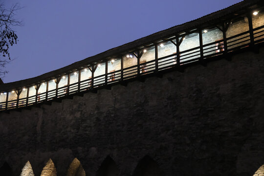 Low-angle dusk view of the wooden walkway atop Tallinn town wall 