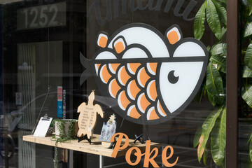 Fototapeta premium exterior building facade and vinyl window sign of Umami Poke, a Hawaiian restaurant, located 1252 Yonge St inside Summerhill Gardens, Toronto