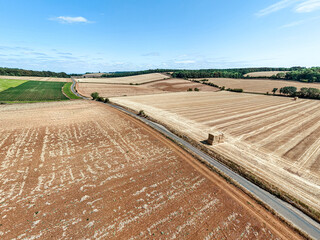 Fototapeta premium An aerial drone shot of fields on the Cotswolds during the August 2026 drought near Snowshill, Gloucestershire, England UK. The field in the foreground appears to be a failed crop of peas.