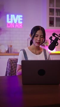 Asian influencer talking in broadcast on social media live on Laptop and smartphone recording online,greeting listeners with coaching life,Stratagem or business at modern home studio.broadcast concept