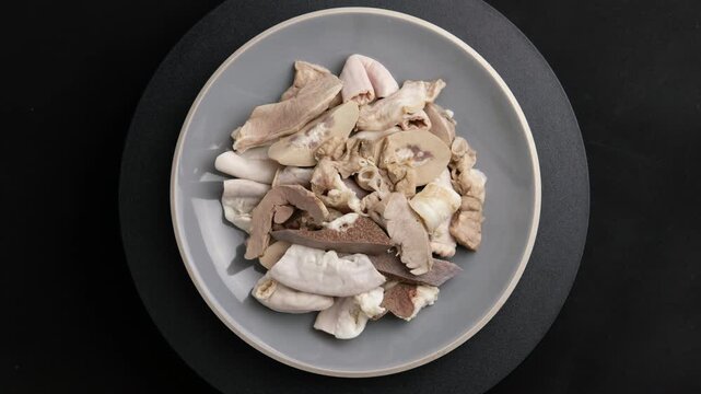 Pork Giblets or Pig Offal in a plate.Boiled Mixed Pork Offal ,Intestines ,Guts ,Chitterlings ,Heart ,Kidney ,Liver ,Spleen and Lung.Top view.	