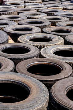 an organized stack of worn-out, end-of-life heavy-duty truck and commercial vehicle tires