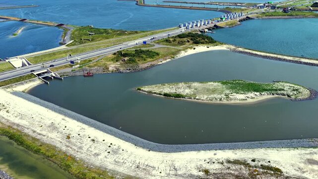Aerial view of the Vismigratierivier fish migration river with its winding channel and surrounding dikes in Kornwerderzand, Friesland, Netherlands.