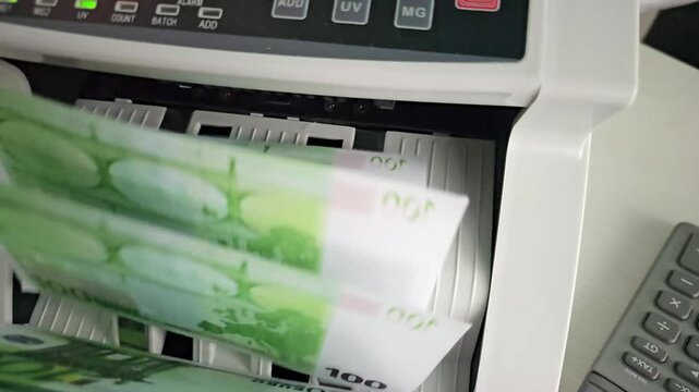 Using a money counter to count and sort euro banknotes in an office setting