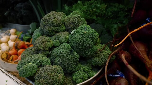 broccoli displayed in plastic containers on wooden shelves in a grocery store produce section close-up neutral mood food products shopping green brown commercial natural light clean copy.