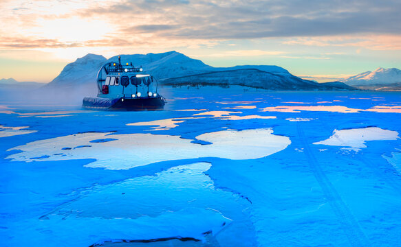 Hovercraft rides on Lake Baikal ice at sunset - Ogoy island on winter Baikal lake with transparent cracked blue ice at sunrise - Baikal, Siberia, Russia
