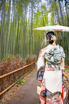 Japanese woman wearing japanese traditional kimono - Bamboo forest at Arashhiyama district in Kyoto, Japan