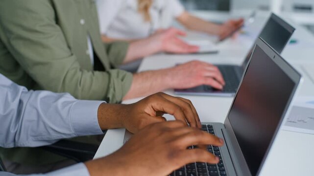 Closeup cropped view three diversity business coworkers working typing laptops in office unrecognizable team businessmen work computers businesswoman writing notes using digital tablet working process
