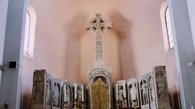 Monumentaler Hochaltar mit keltischem Kreuz und christlichen Statuen in einer Kirche
