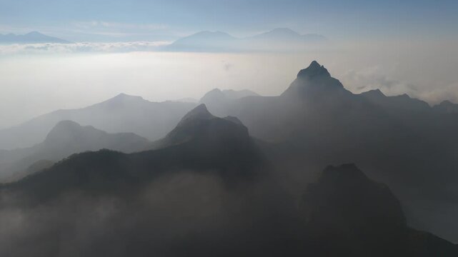 Aerial view of the misty peaks of Gunung Kelud rising above the clouds in Kecamatan Ngancar, Jawa Timur, Indonesia.